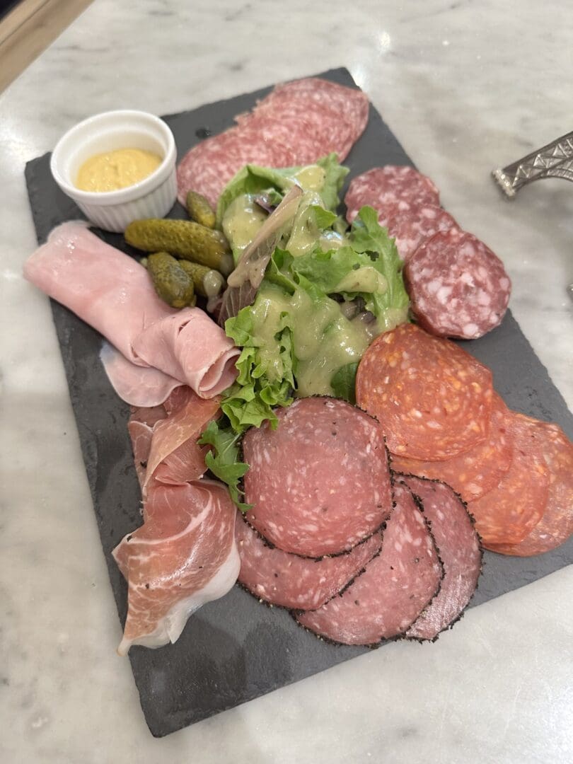 Charcuterie board with meats and pickles.