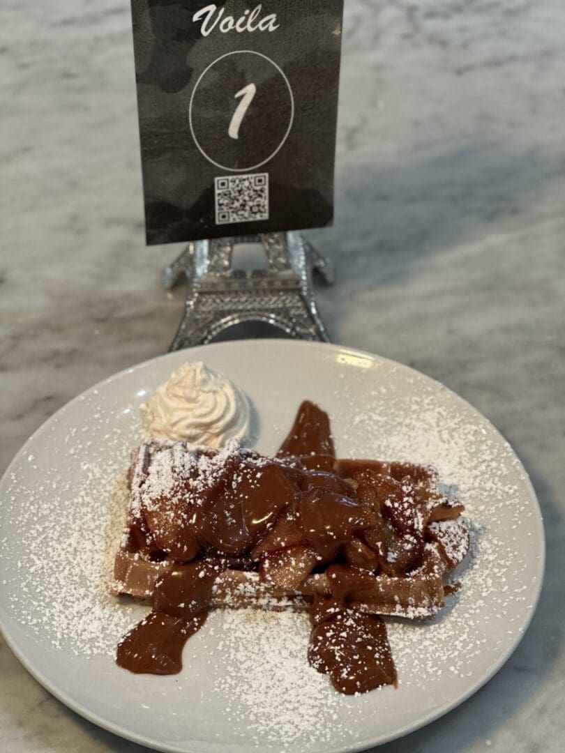Waffle with chocolate sauce and whipped cream.