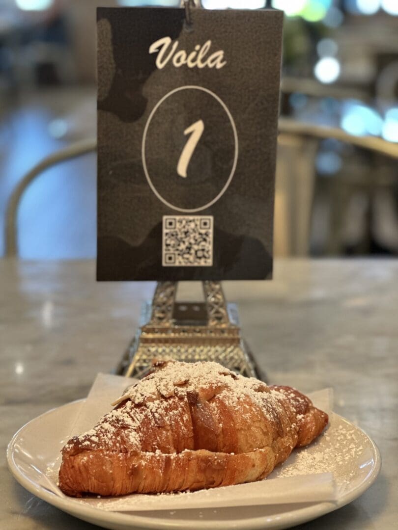 Croissant on plate with table number sign.